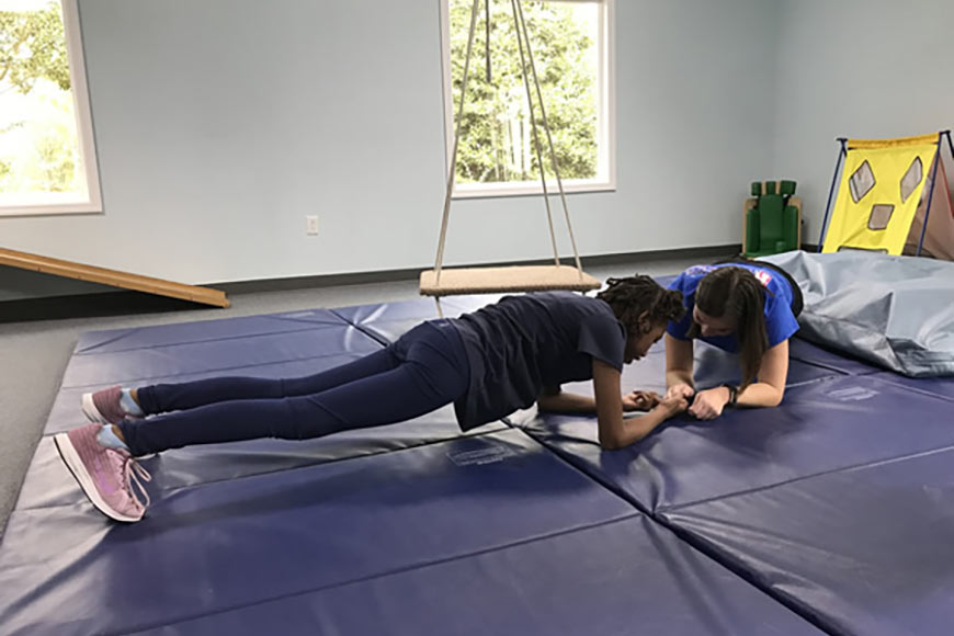 Photo of a young girl doing physical therapy with therapist