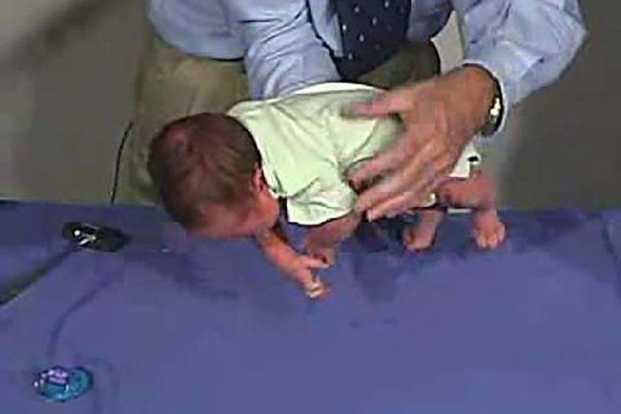 Video still of a therapist holding a baby