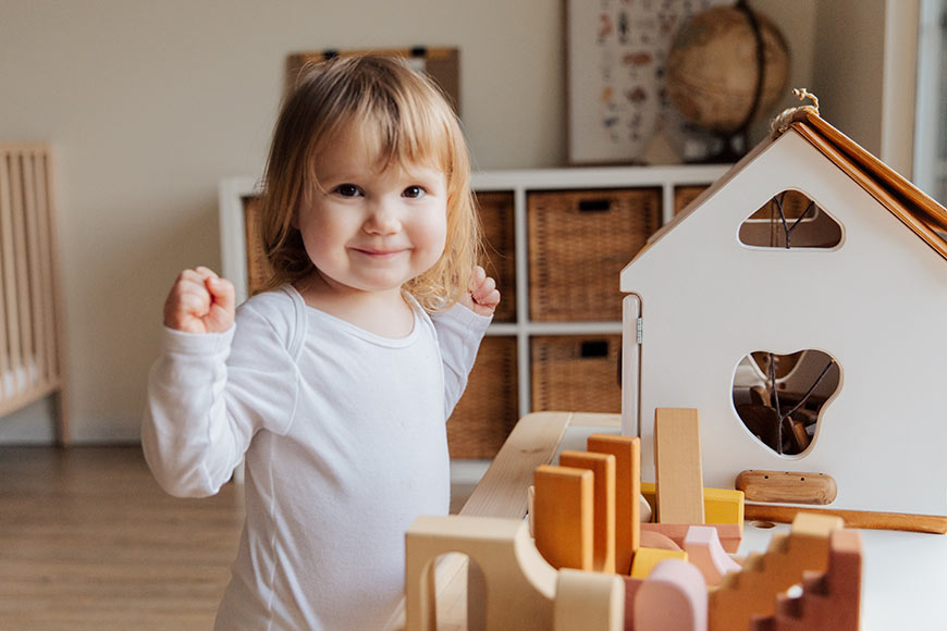 Photo of a smiling little girl playing in her room