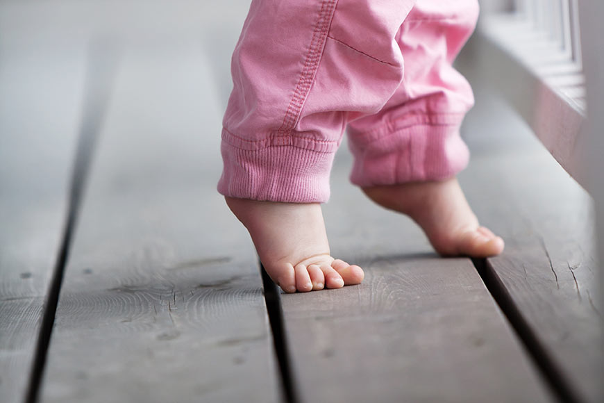 Photo of a baby walking on her toes