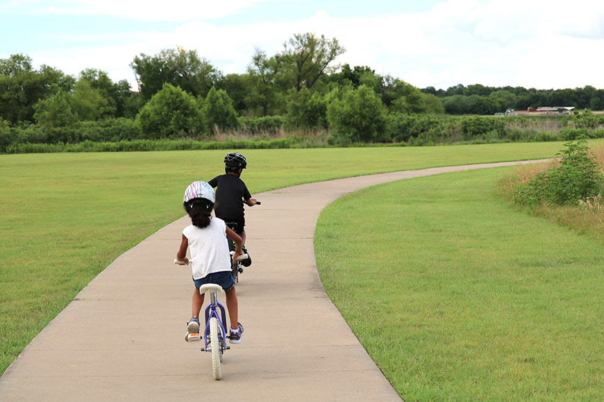 Photo of two children riding bikes