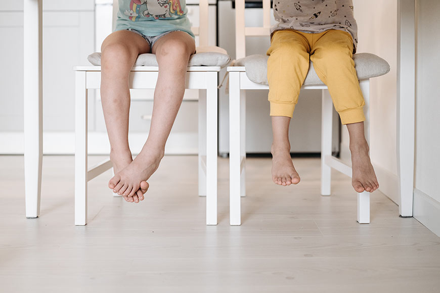 Photo of dangling feet of children sitting on chairs