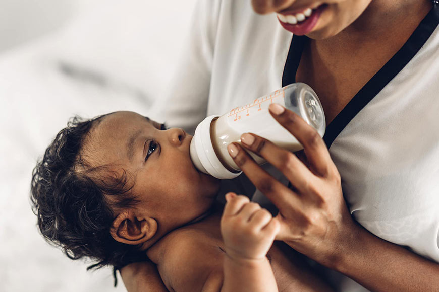 Photo of a woman bottle feeding a baby