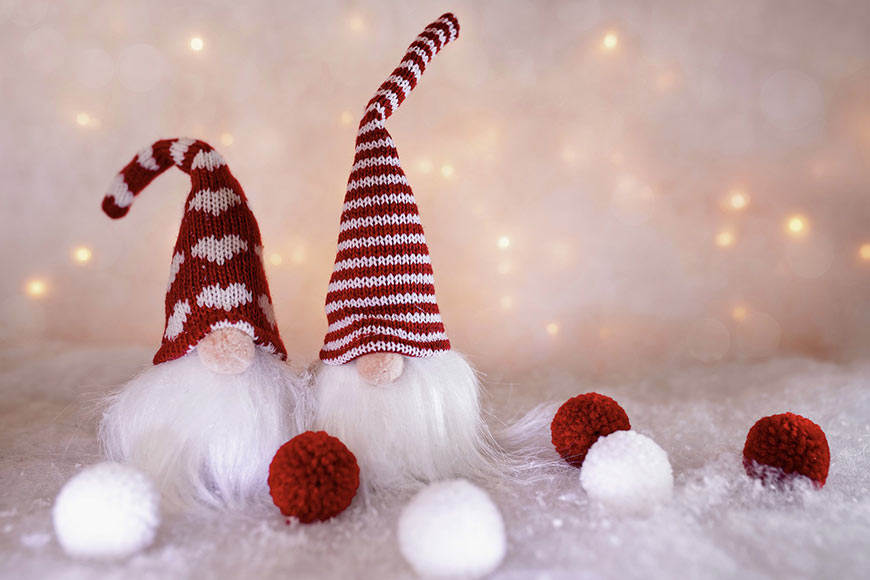 Photo of two Christmas elves made of fabric and white lights in background