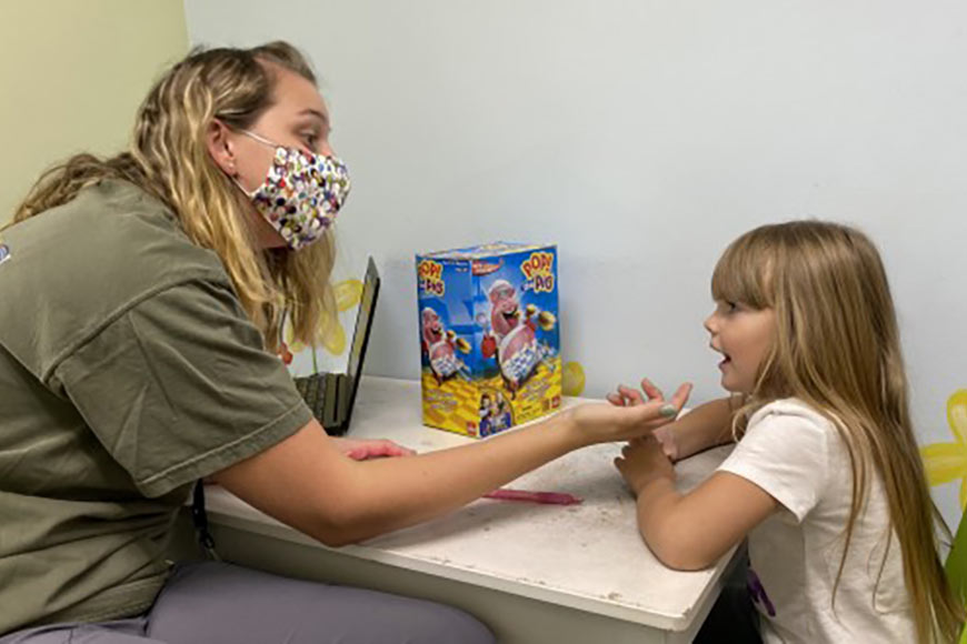 Photo of a little girl doing speech therapy with therapist