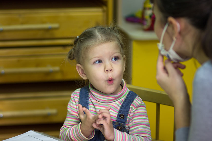Photo of a little girl doing speech therapy
