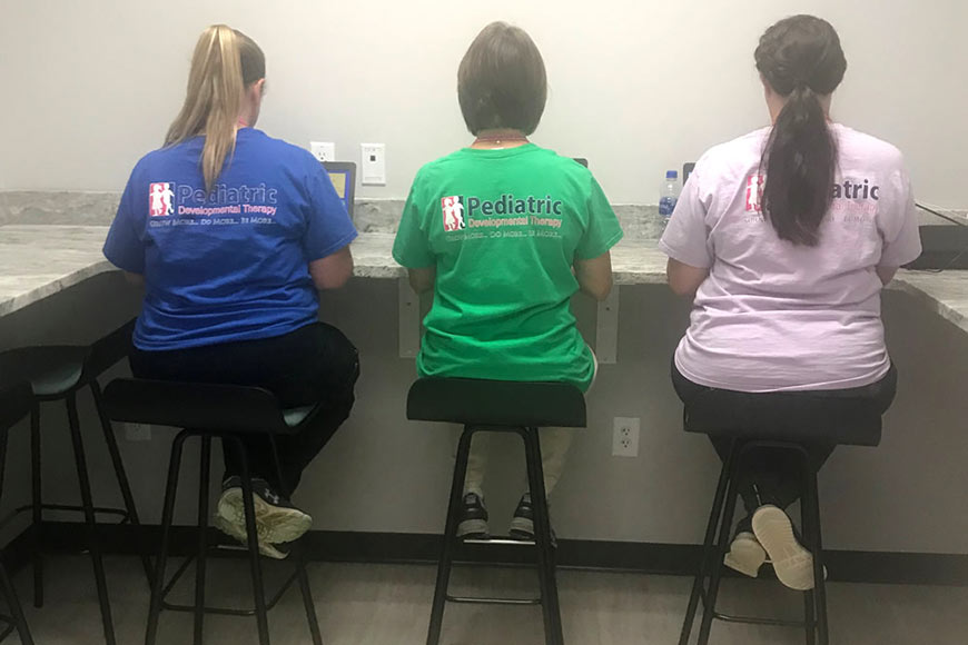 Photo of PDT staff sitting in break room wearing PDT t-shirts