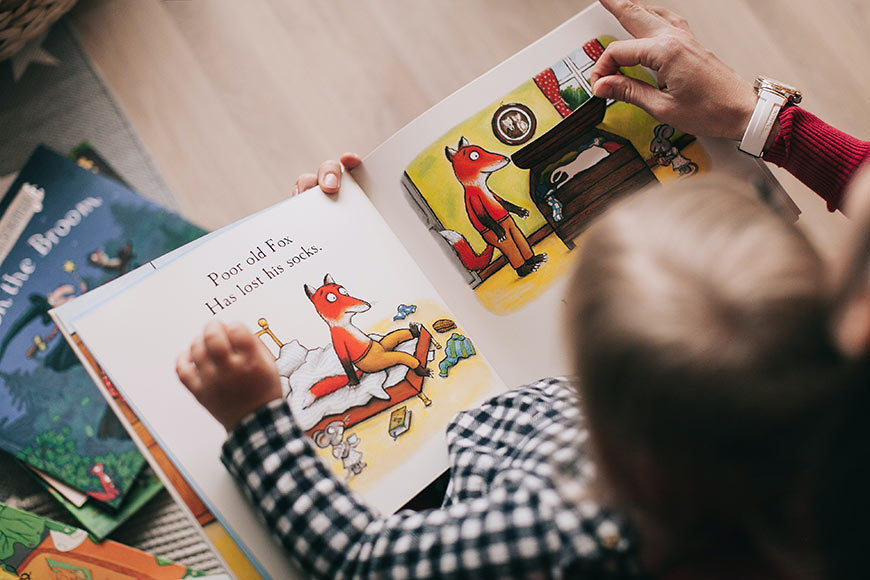 Photo of a little boy reading a children's book