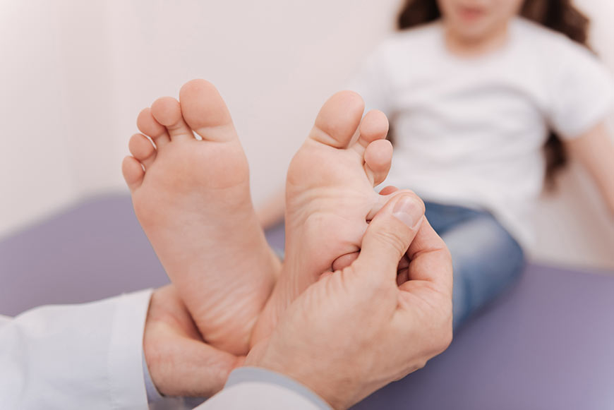 Photo of a doctor examining a little girl's feet